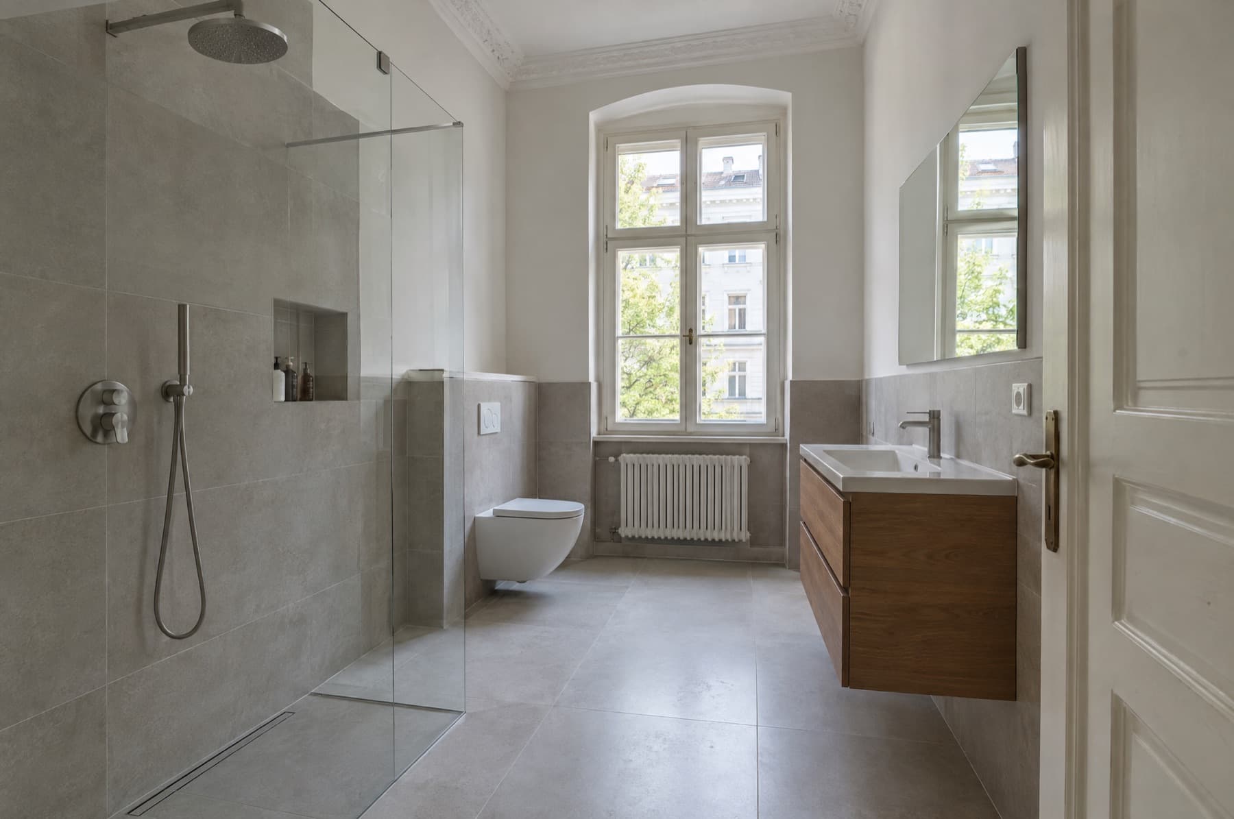 Saniertes Bad in einer Berliner Altbauwohnung mit bodengleicher Dusche und Stuckdecke